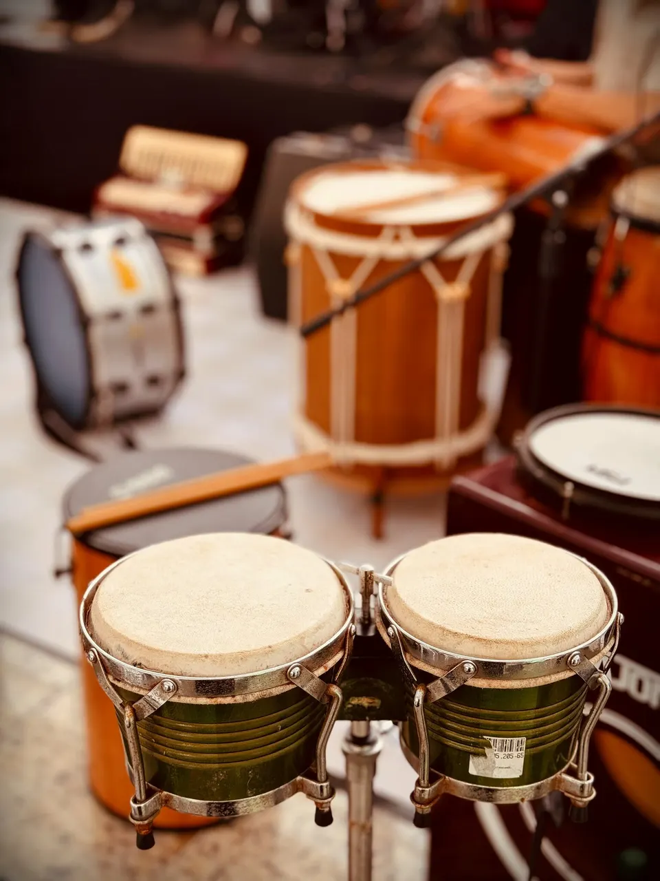 Bongôs, congas e tambores da escola, lado a lado.