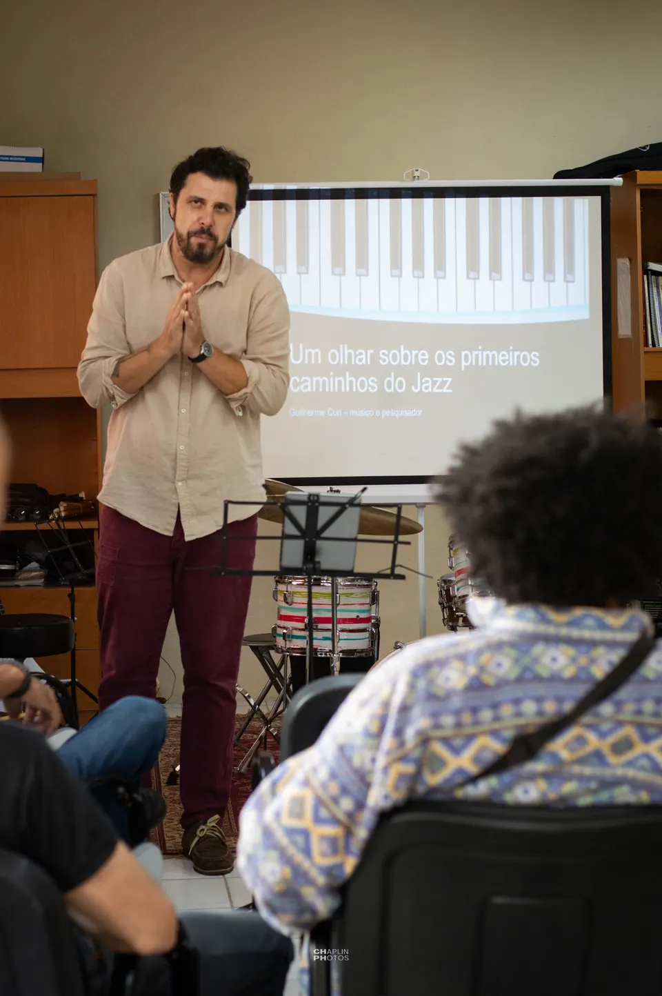 Palestra sobre os primeiros caminhos do jazz, com o tema projetado no telão.