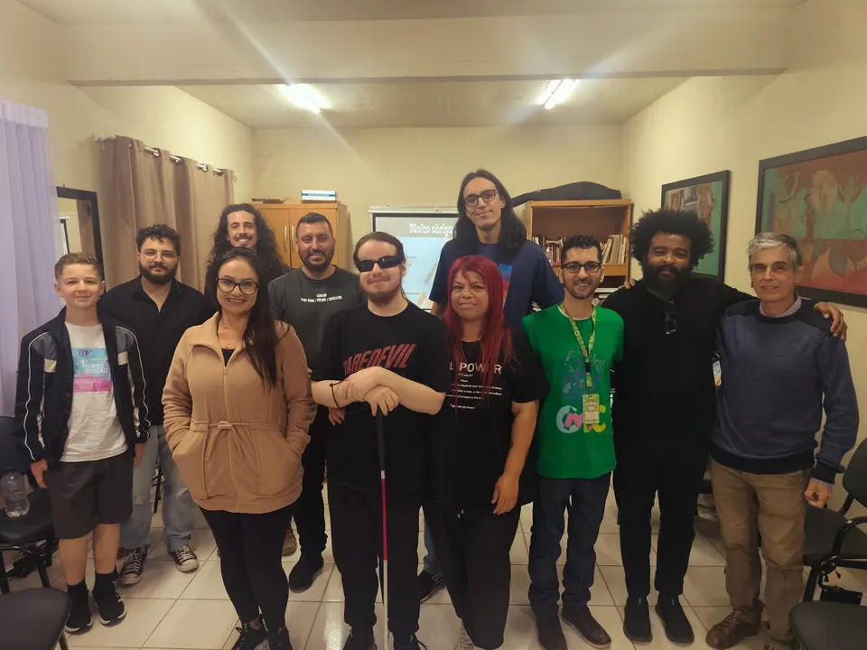 Participantes do 2º Mentes MusiCaos posam juntos na sala.