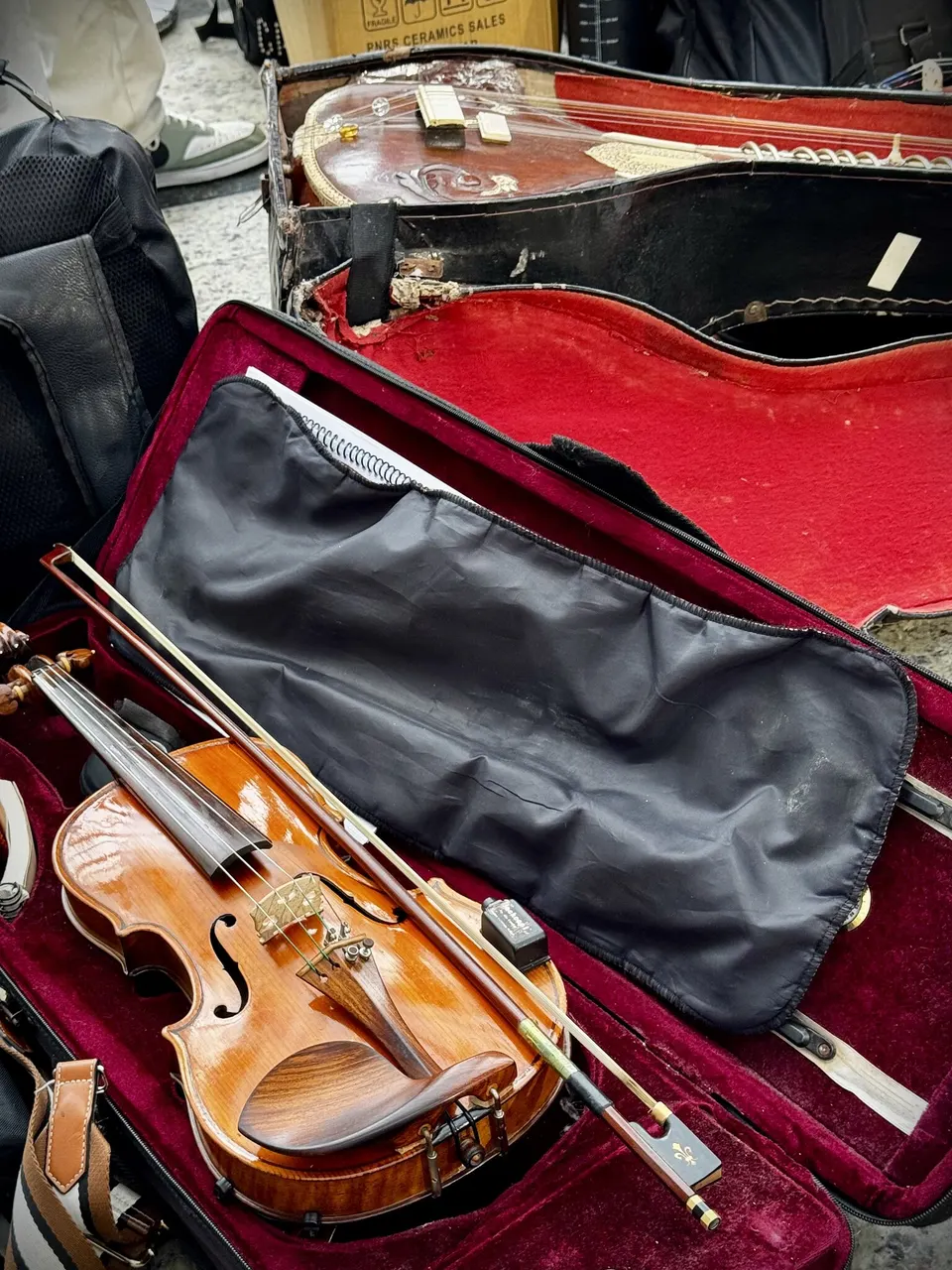 Violino guardado num estojo aberto, entre os instrumentos da escola.